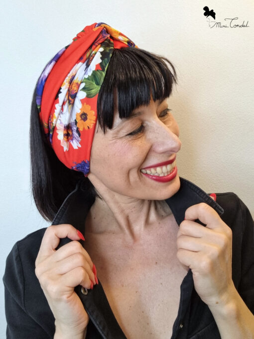 Mimi Condal con turbante a fascia rossa con stampa fiori.