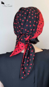 Turbante reversibile rosso e nero annodato con due lembi incrociati frontalmente, Mimi Condal.