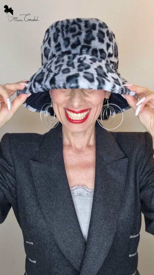 Mimi Condal indossando cappello a secchiello in pelliccia sintetica leopardata grigia.