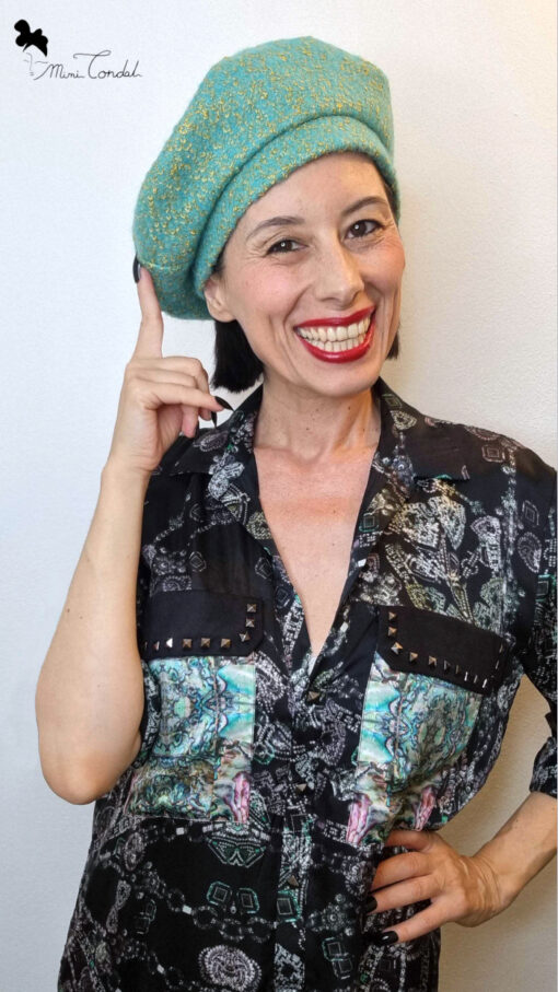 Mimi Condal mostra come portare cappello basco color acquamarina inclinato su un lato.
