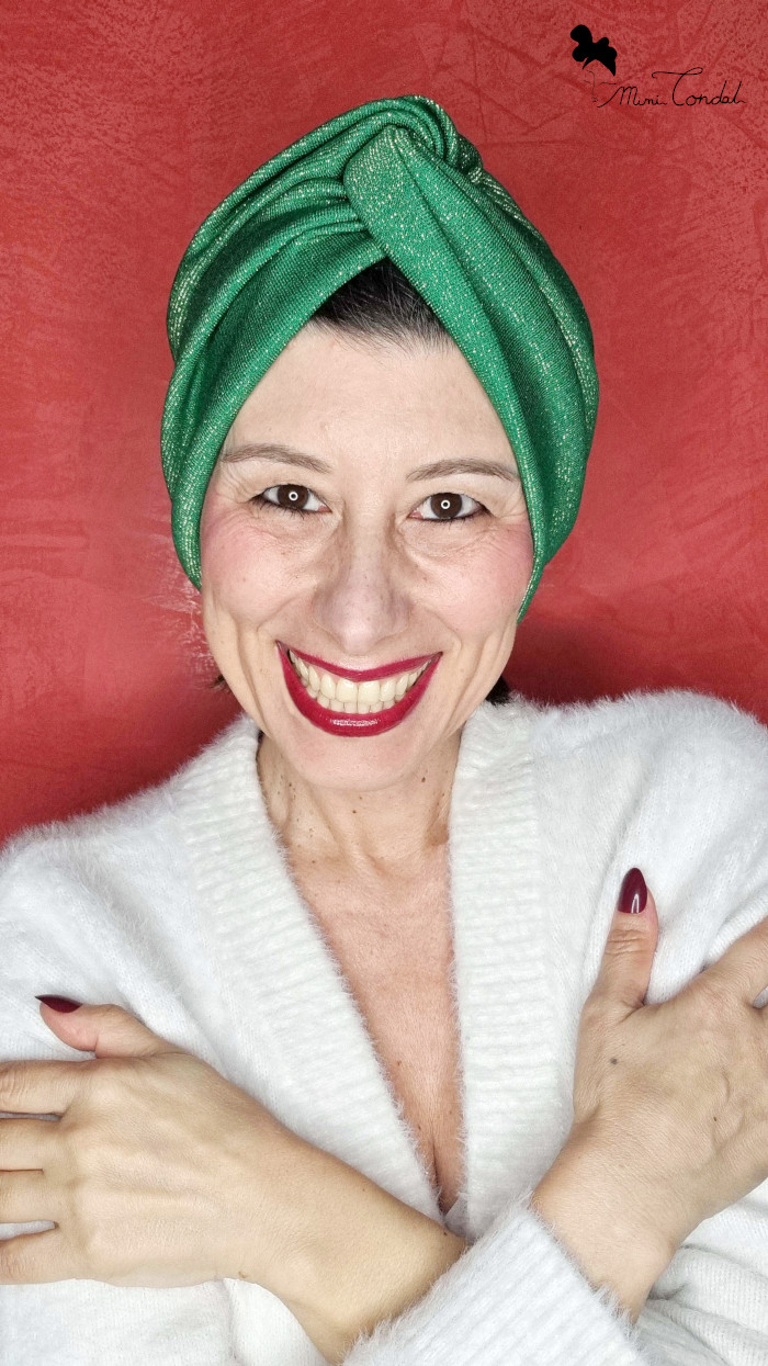 Mimi Condal mostrando come s'indossa il turbante in jersey verde con lurex con nodo frontale ed arricciatura posteriore.